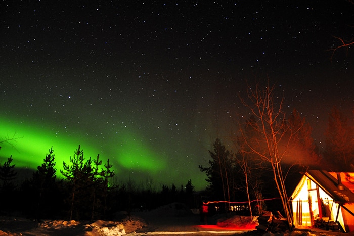 Cabana e a Aurora Boreal ao fundo | Foto por Livia Auler