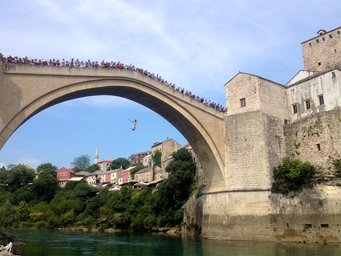 A ponte Stari Most, em Mostar, nos dias de verão, é ponto de saltos livres e; à noite, encontro da boemia.  |  Foto de Sabrina Sasaki